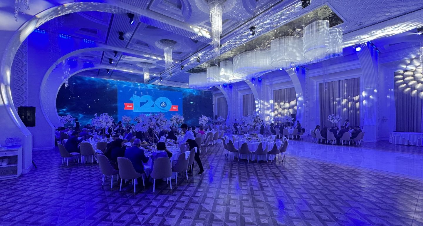 Большой зал FIESTA HALL в синем свете, накрытые столы и экран во всю стену